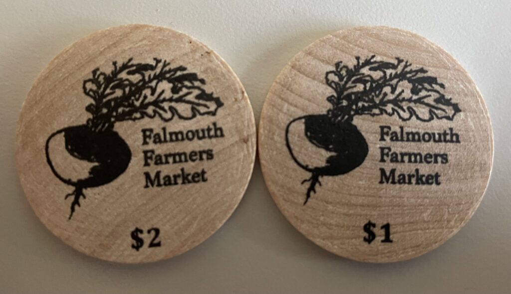 wooden tokens with turnip and Falmouth Farmers Market printed on them
